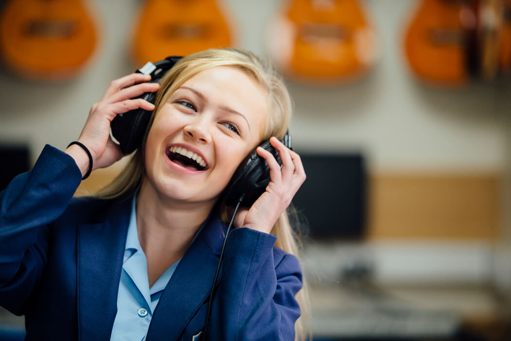 Schoolgirl wearing headphones laughing