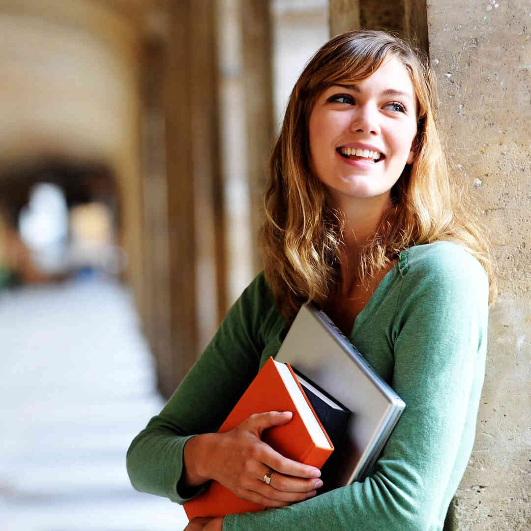 Smiling female student with books